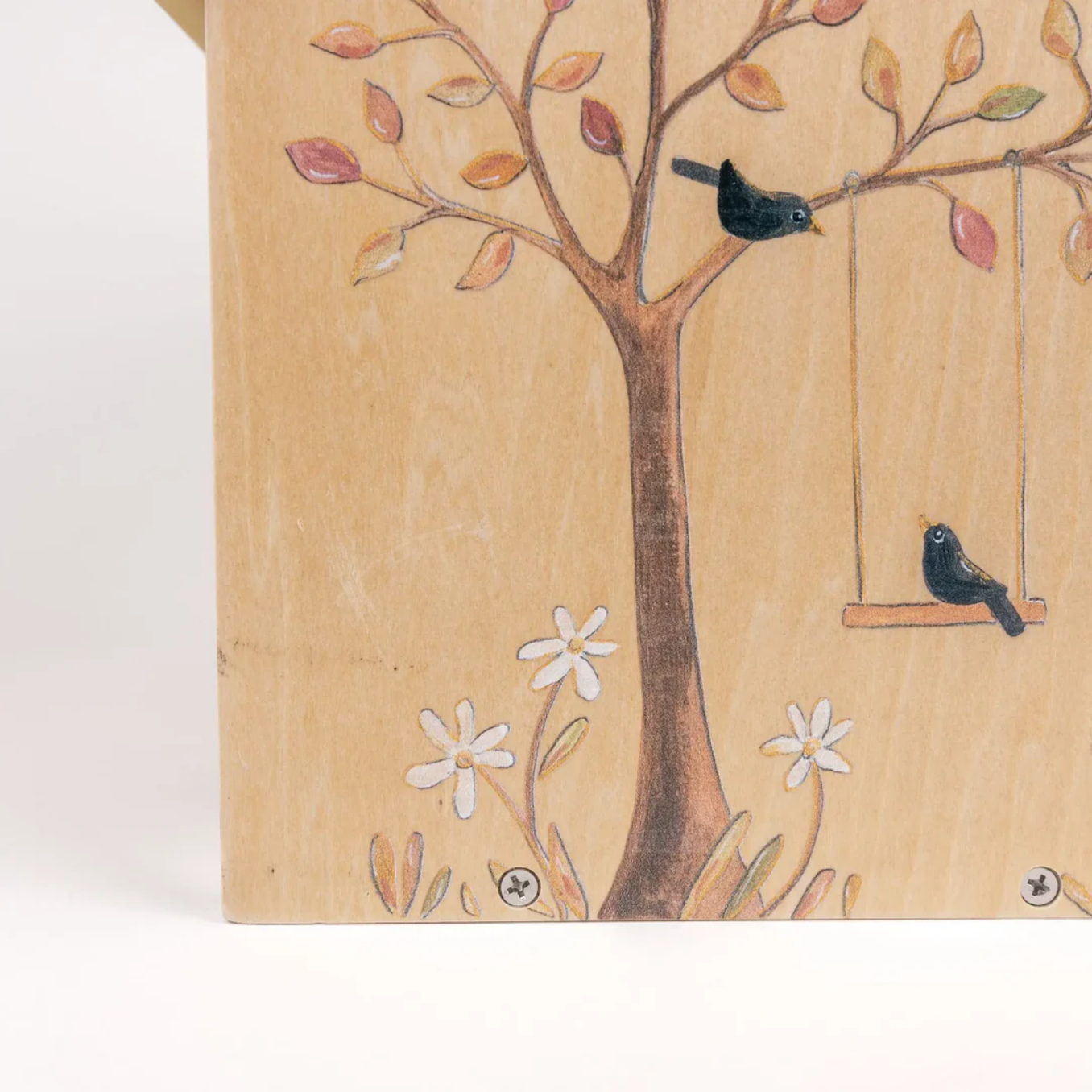 Wooden detail with a tree design featuring birds and flowers on a beige background