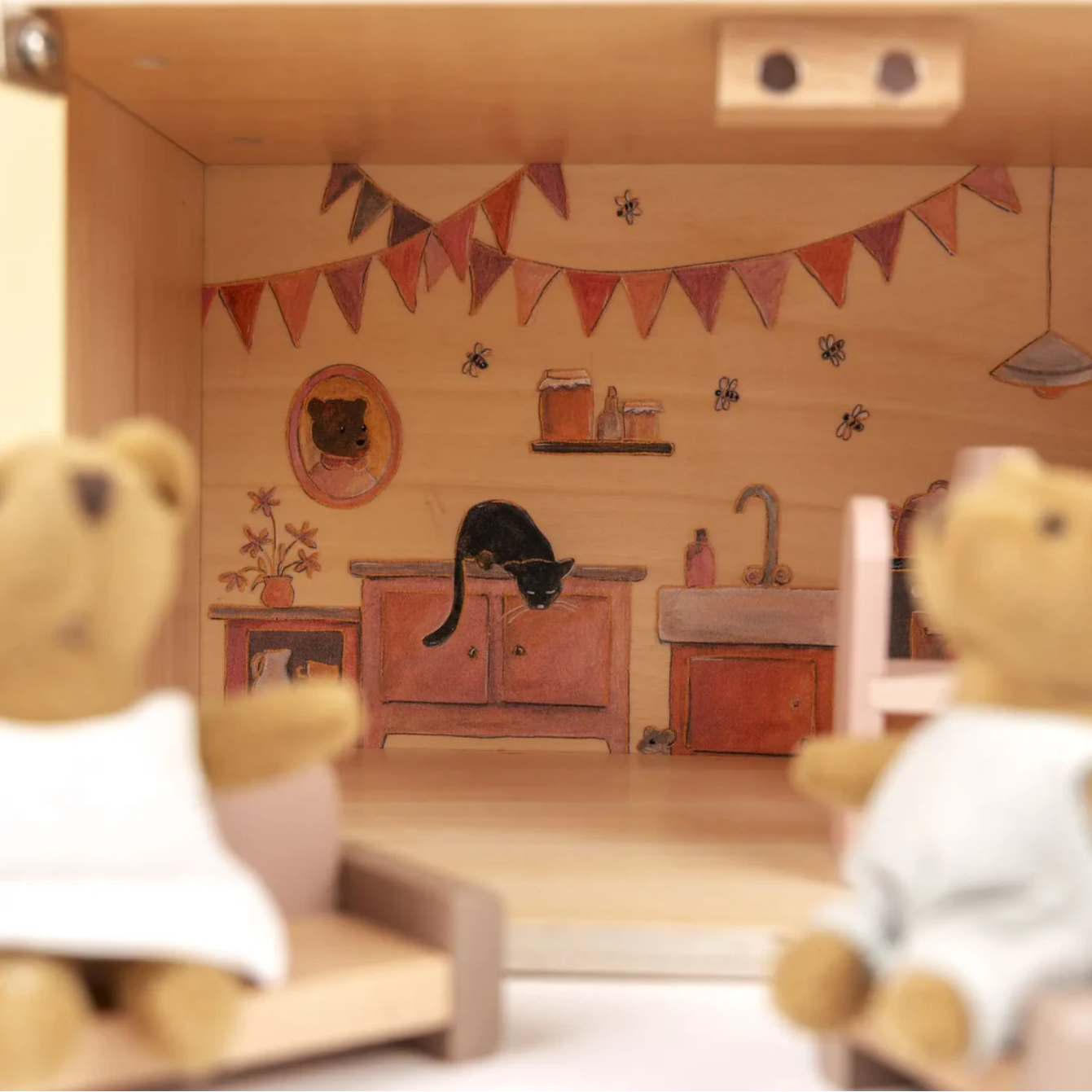 Two teddy bears in a room with a cat on a cabinet, decorated with flags and a clock.