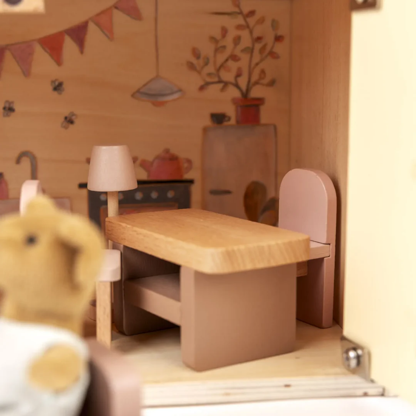 Wooden playset with a teddy bear in a cozy indoor setting