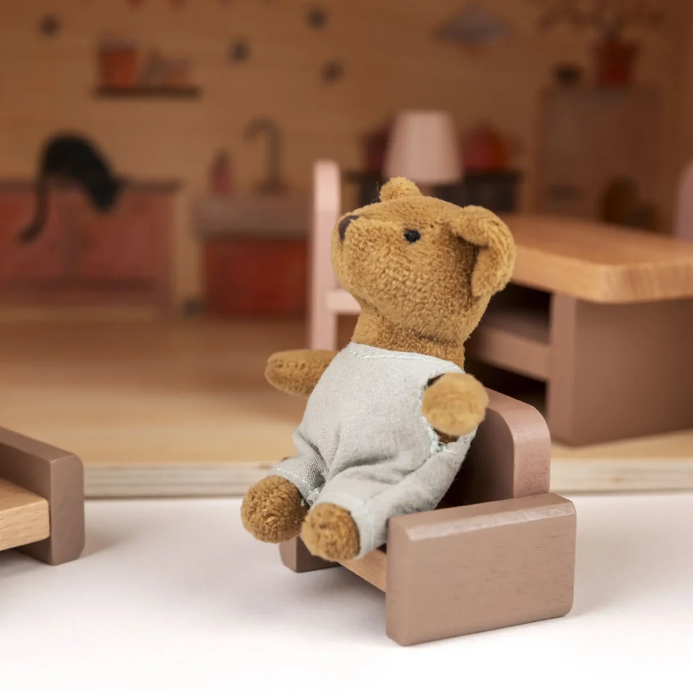 Teddy bear in a small wooden chair in a room setting