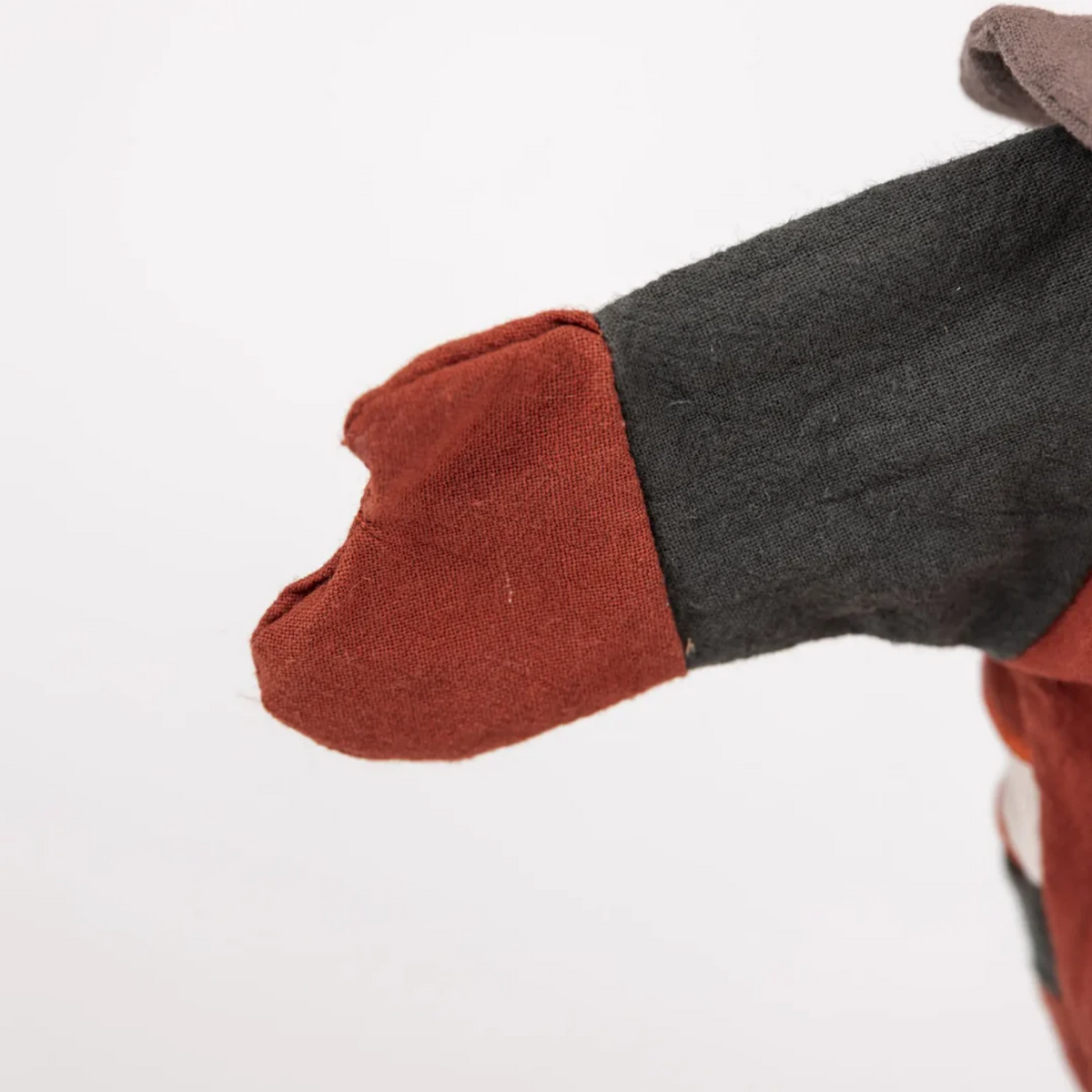 Close-up of a foot wearing a dark gray sock with a red sole on a white background
