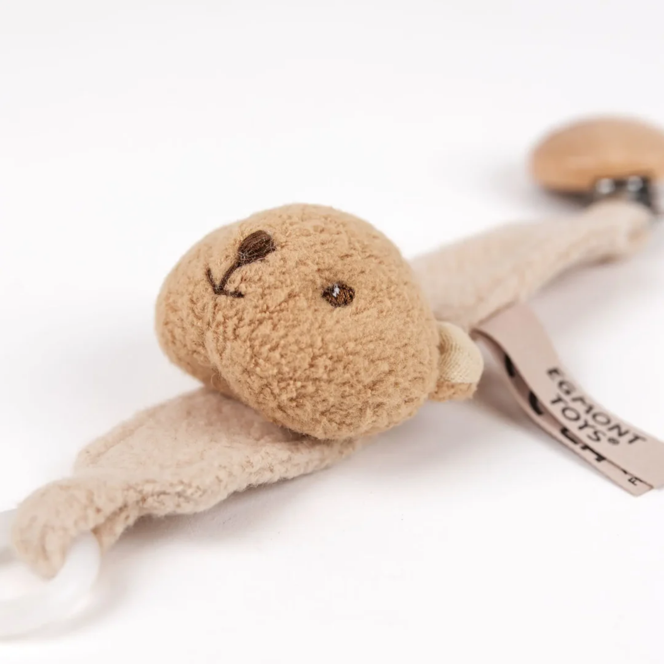Beige plush toy with a tag on a white background