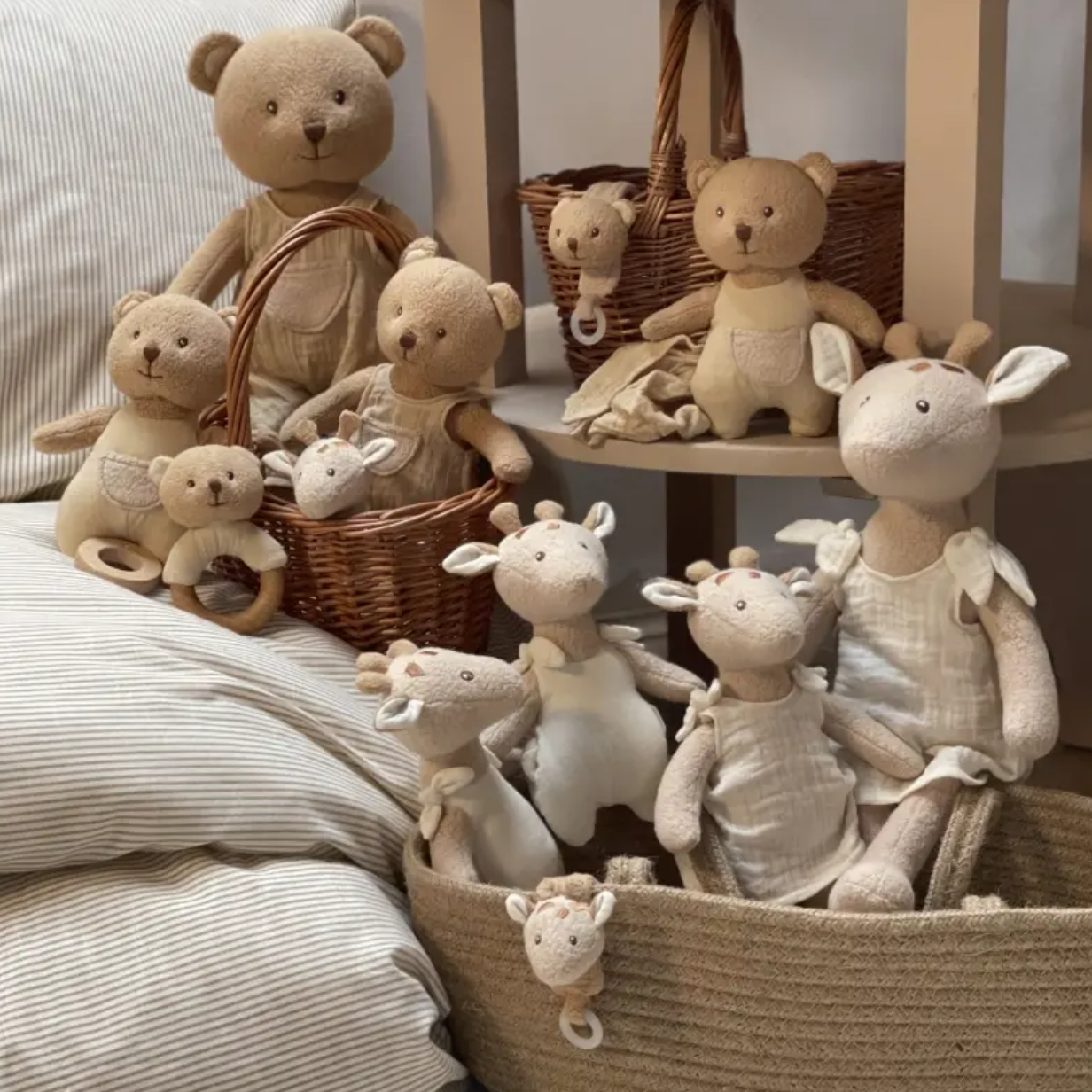 Collection of soft toys including teddy bears and bunnies in baskets on a neutral background