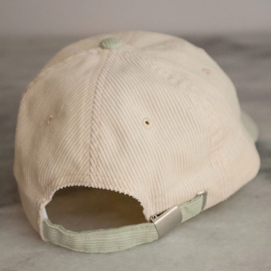Beige corduroy cap on a gray surface