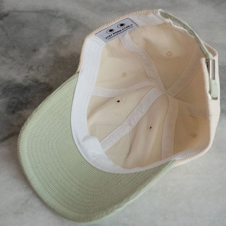 Light green cap with white interior on a gray surface