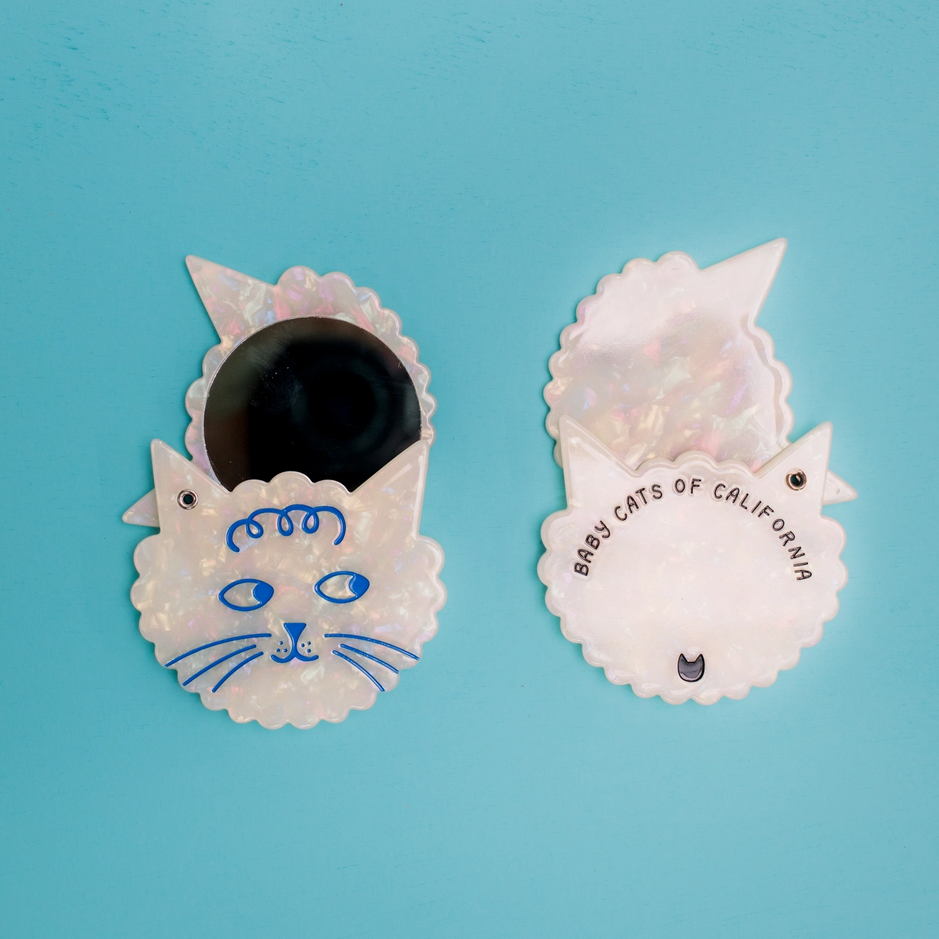 Two cat-shaped hair clips on a blue background