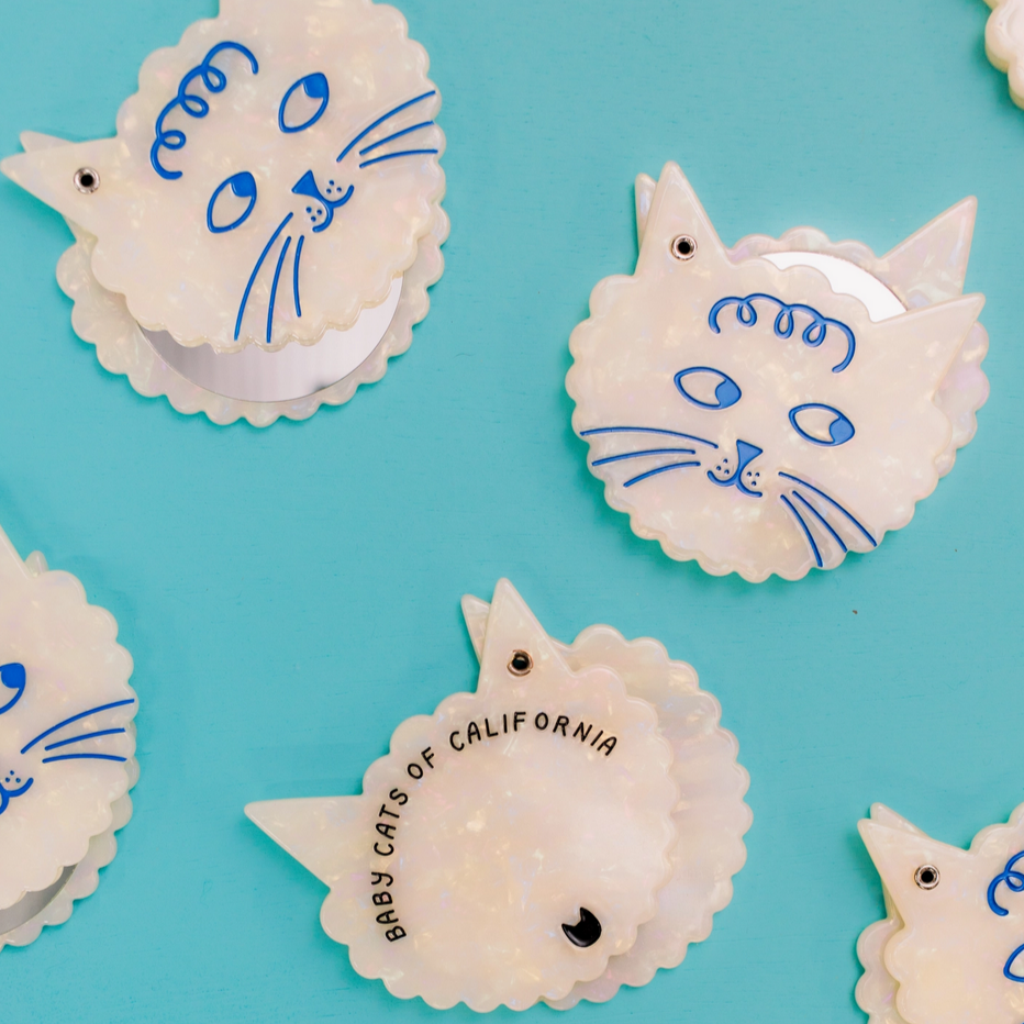 Cat-shaped cookies with blue details on a turquoise background