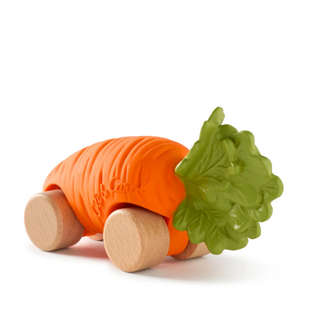 Orange carrot-shaped toy with wooden wheels and a green leaf on a white background