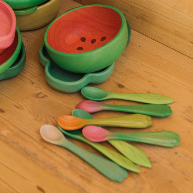 Colorful children's bowl and spoon set on a wooden surface