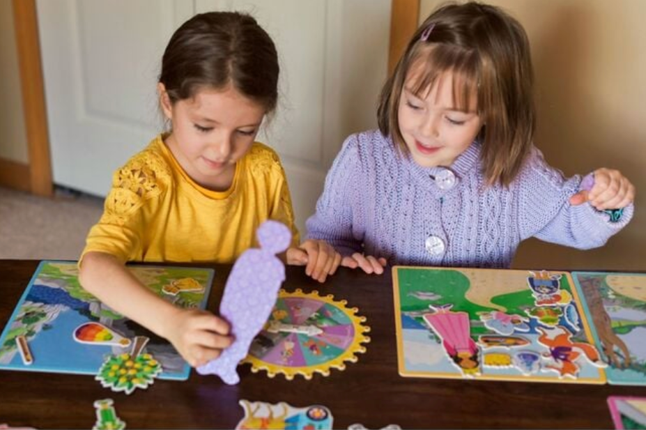 Two children playing with a puzzle at a table.