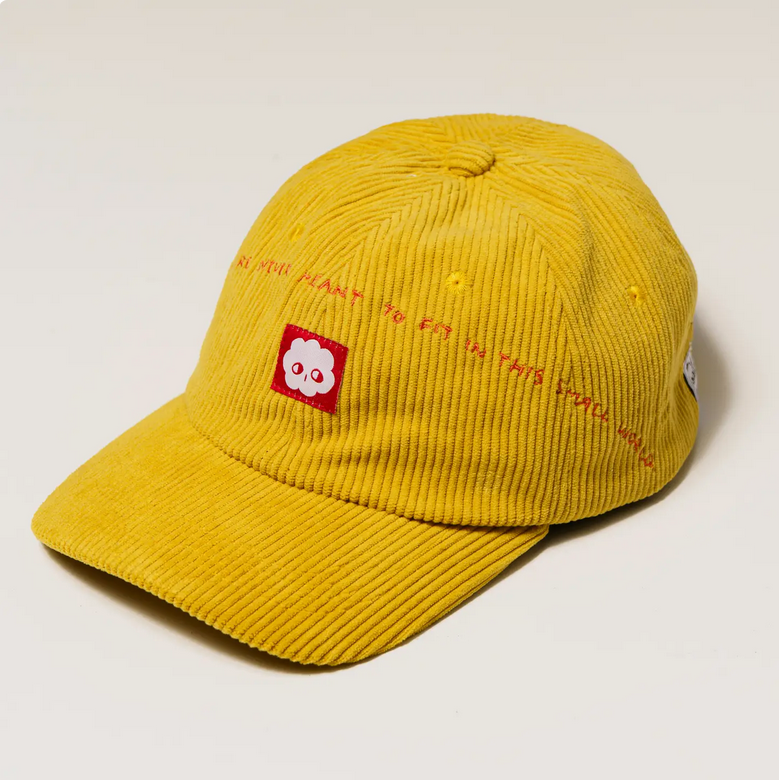 Yellow corduroy cap with a red logo and text on a light gray background