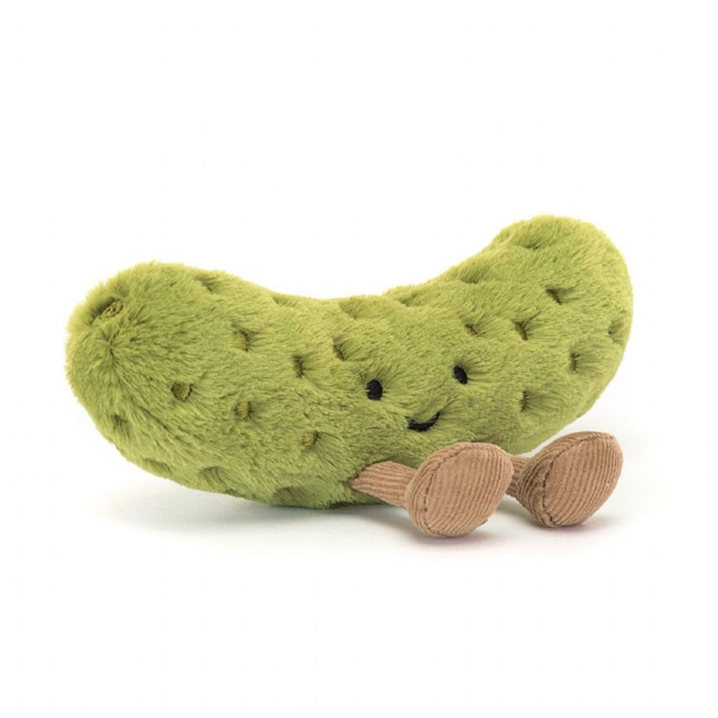 Plush pickle toy with a smiling face on a white background