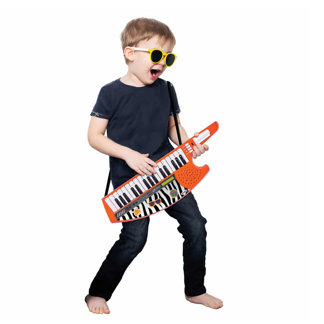 Child playing with a toy keyboard on a white background