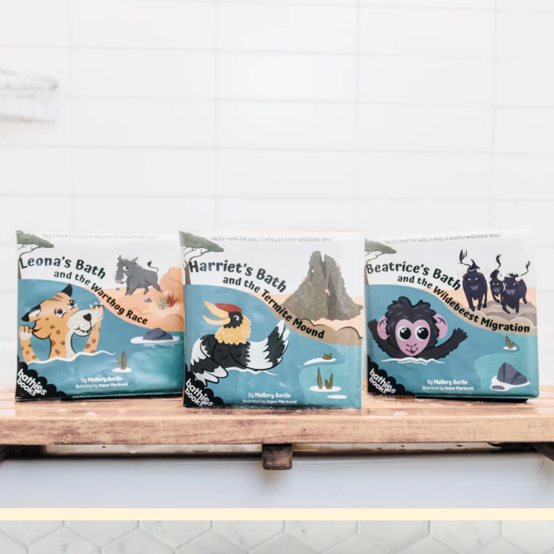 Three children's books on a wooden shelf with a white wall background