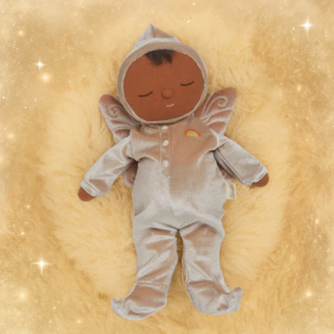 Baby doll in a gray onesie with a hood on a gold background