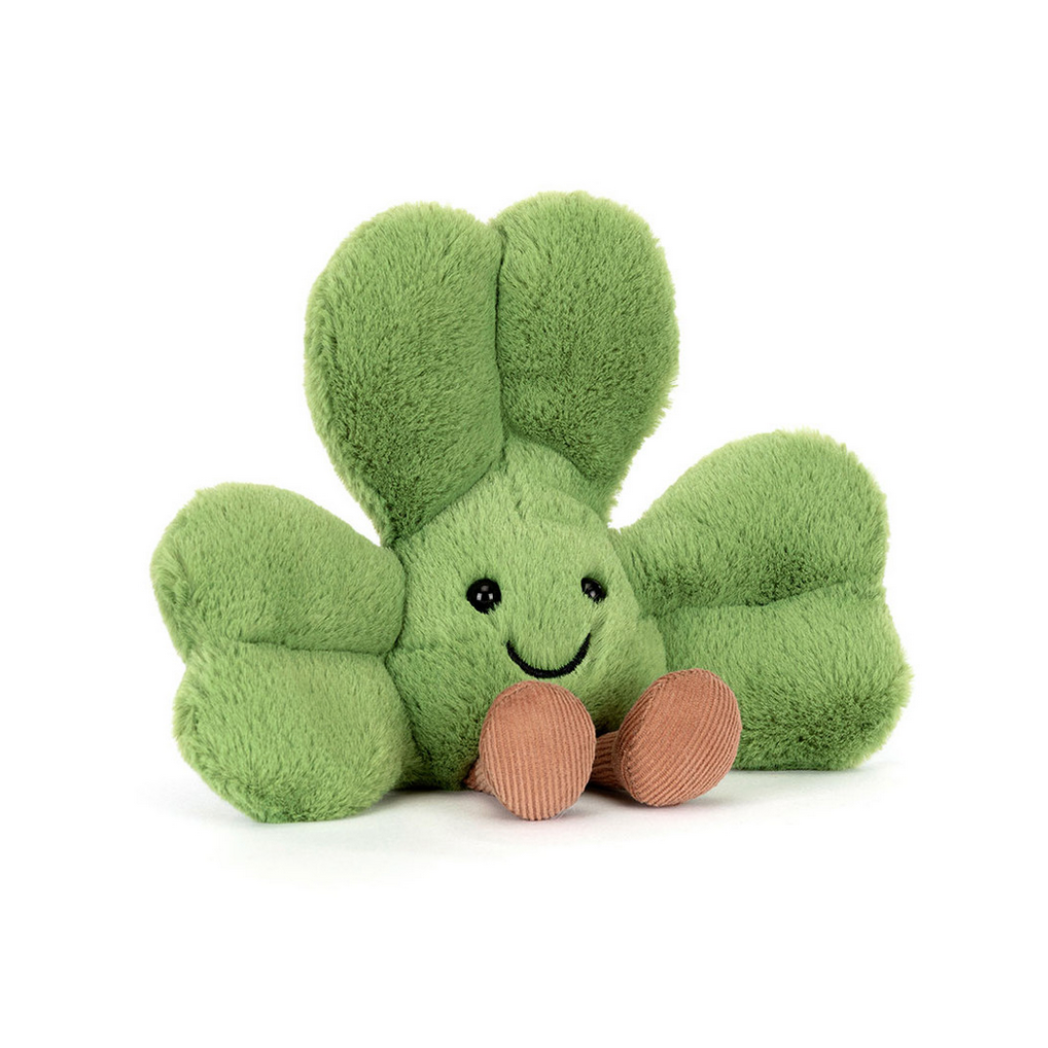 Green plush toy with a smiling face on a white background