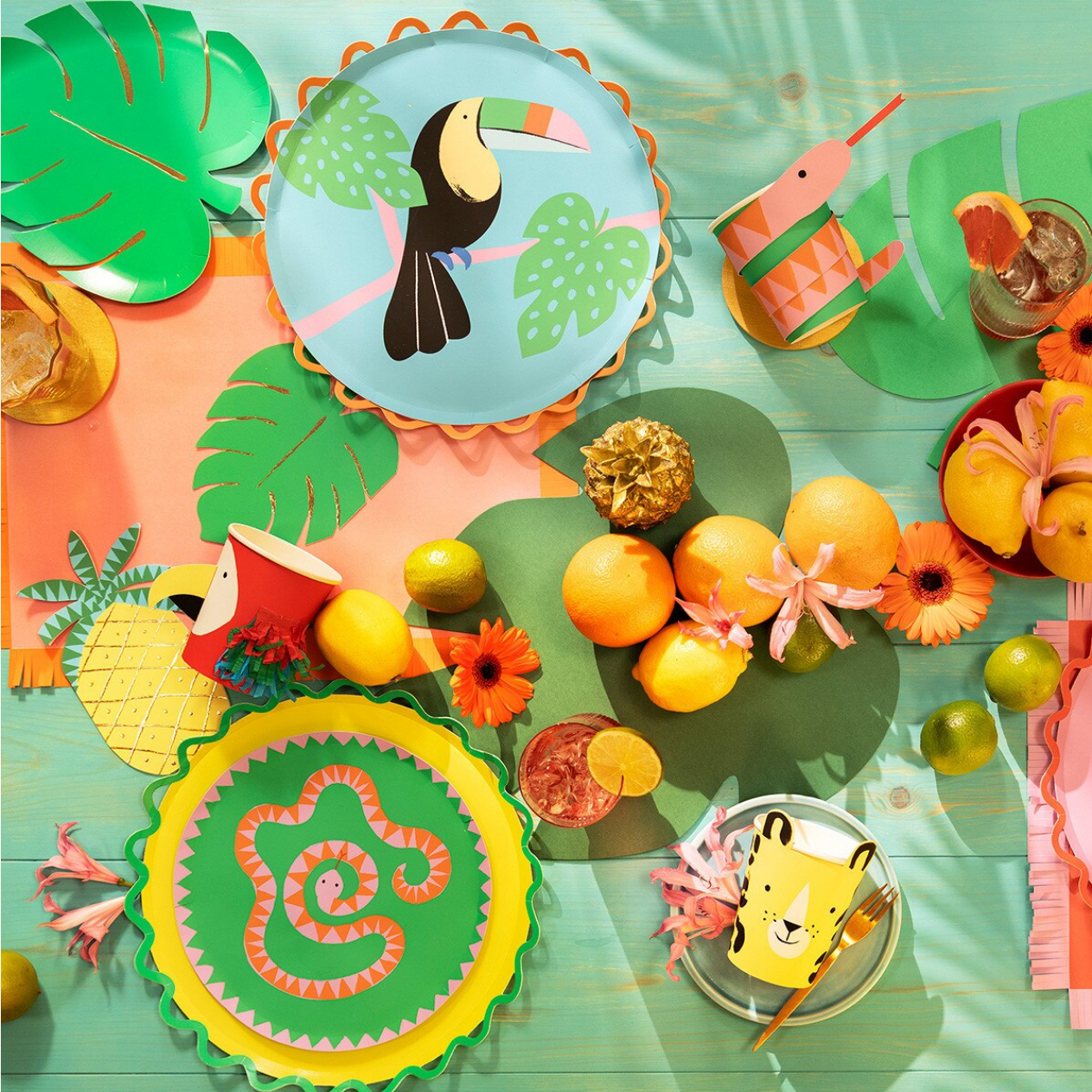 Colorful children's tableware set with animal-themed plates and cups on a vibrant background.