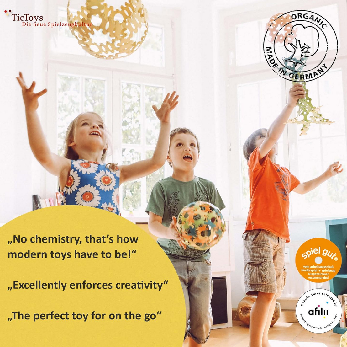 Children playing with toys in a bright room, featuring TicToys branding and organic certification.