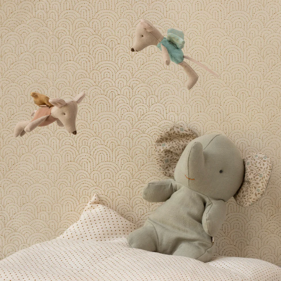 Toy mouse and rabbit on a textured wall with decorative elements