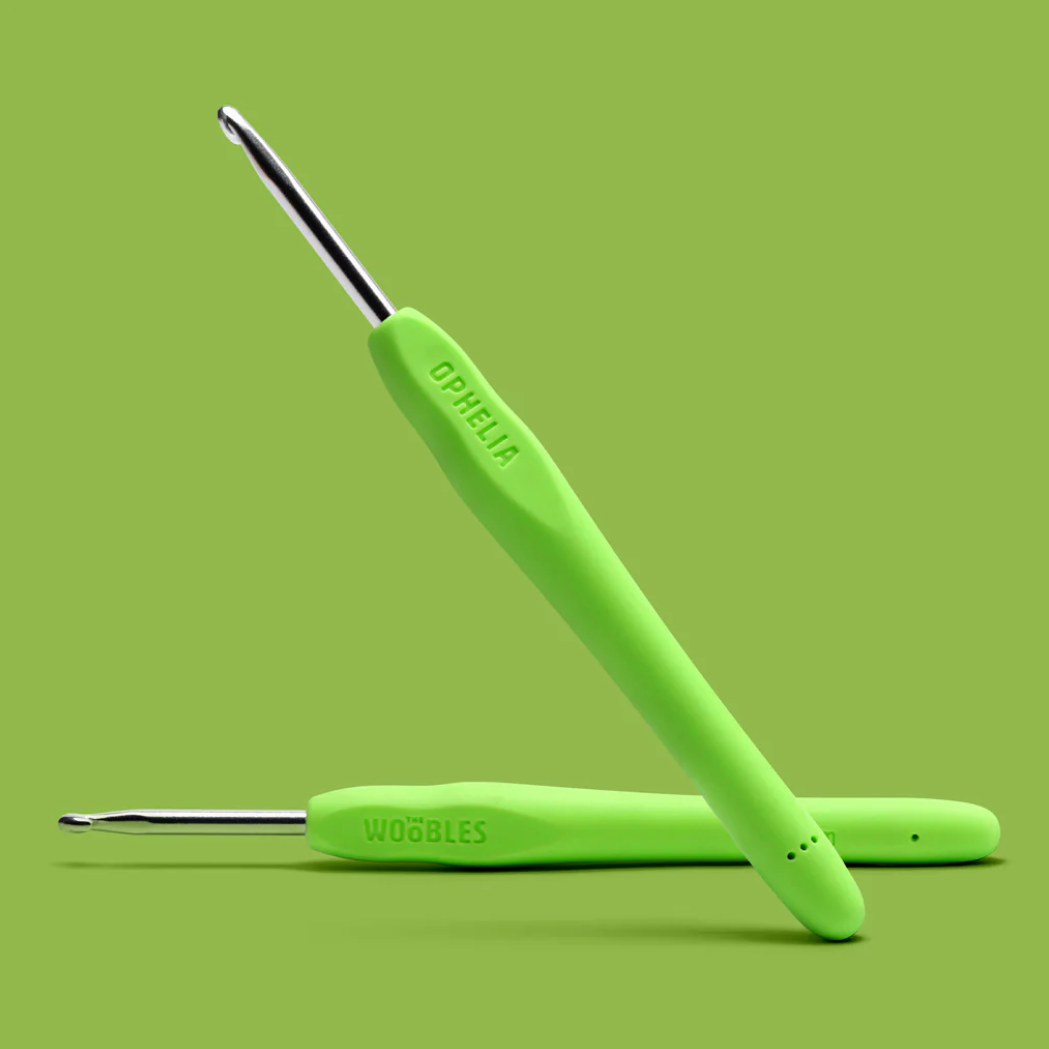 Two green crochet hooks on a green background