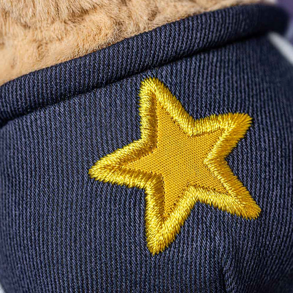Navy blue fabric with a yellow embroidered star on a textured background