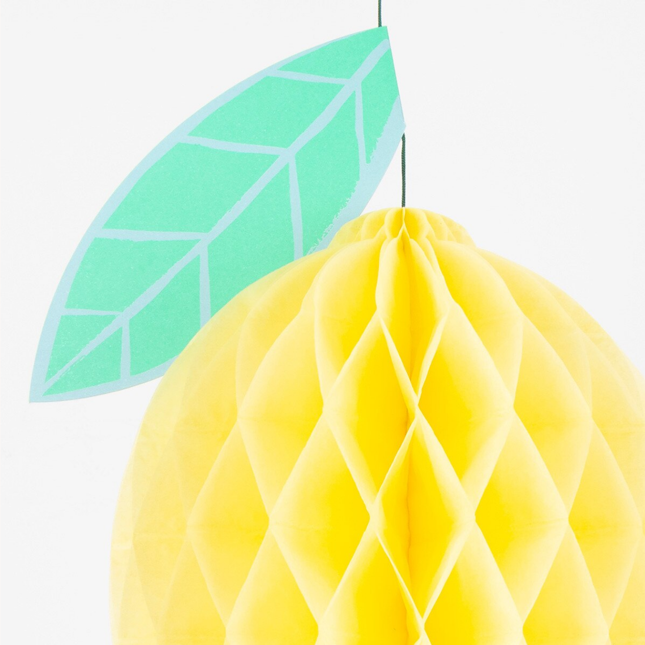 Yellow honeycomb decoration with a green leaf on a white background