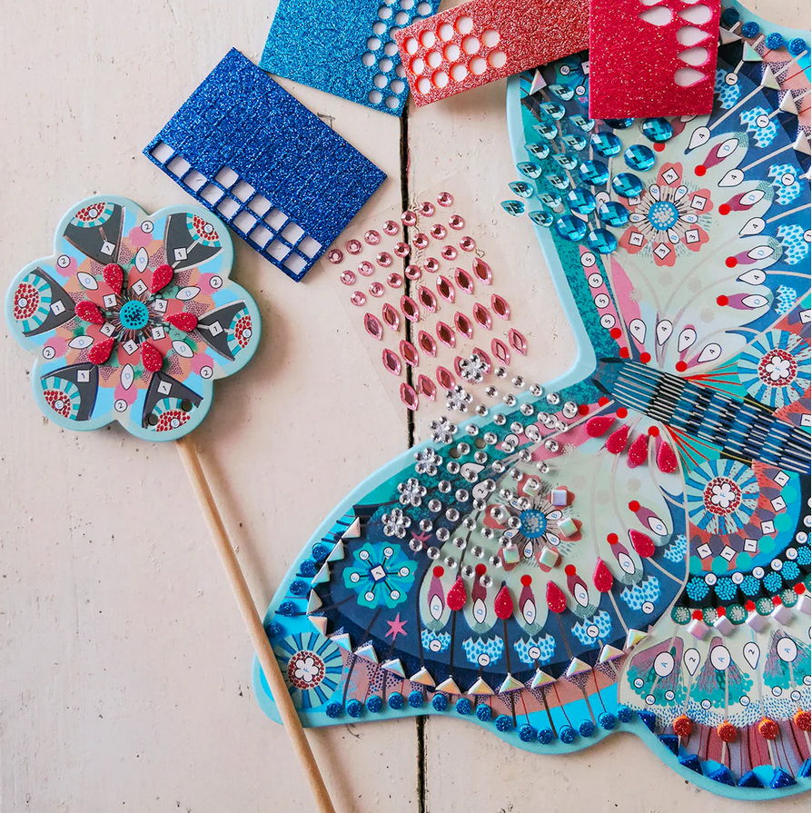 Decorative wings and wand  with blue, red, and multicolor patterns on a light background