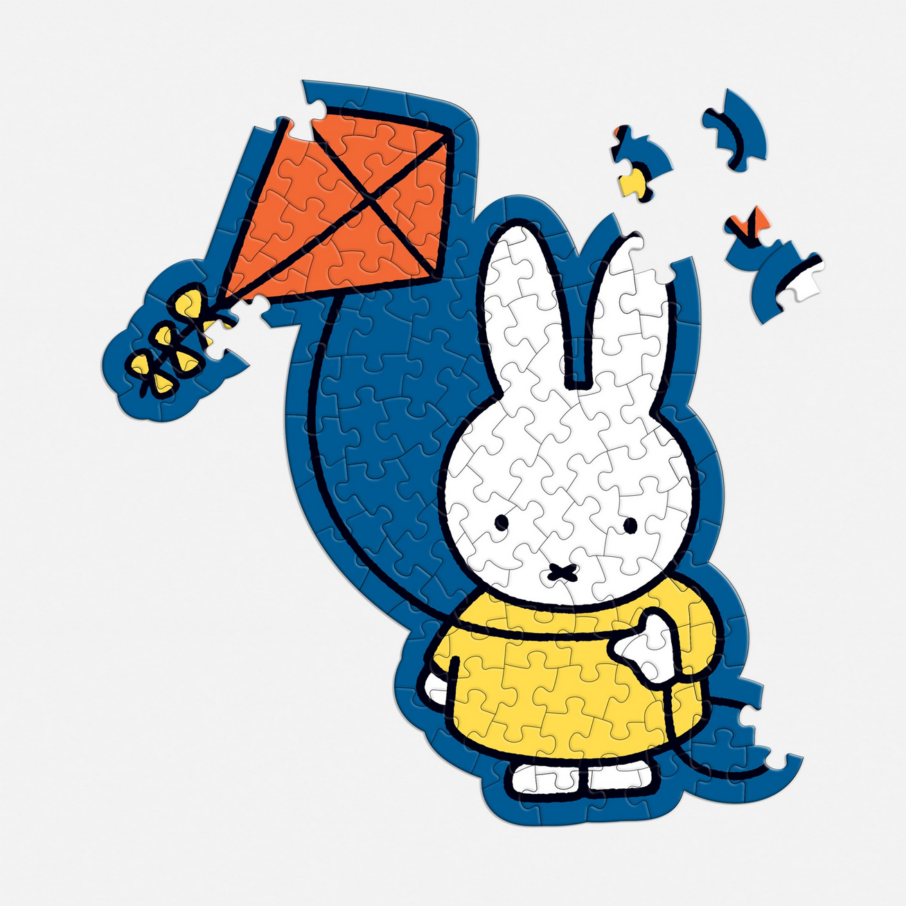 Jigsaw puzzle with a cartoon character holding a kite on a white background