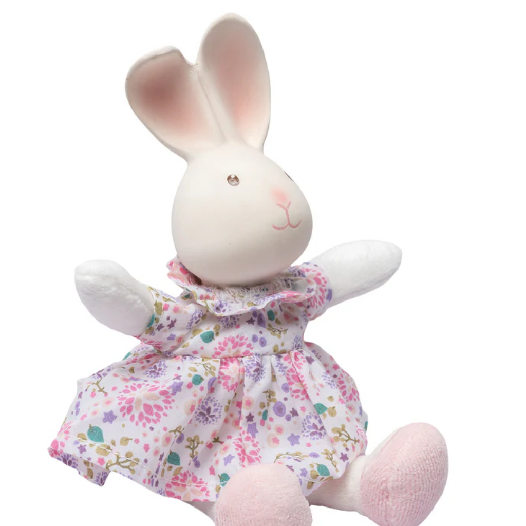 Stuffed rabbit toy wearing a floral dress on a white background