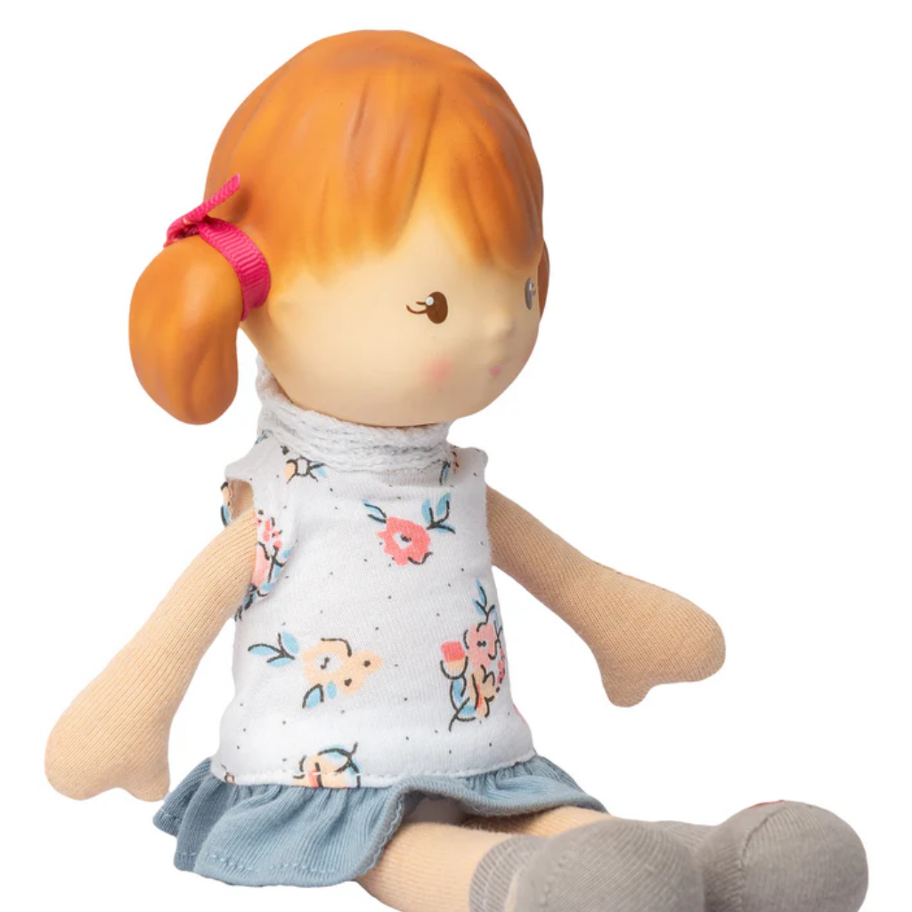 Toy doll with red hair and floral dress on a white background