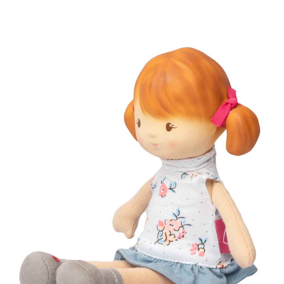 Toy doll with red hair and floral shirt on a white background
