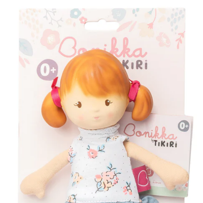 Toy doll with red hair in pigtails on a white background