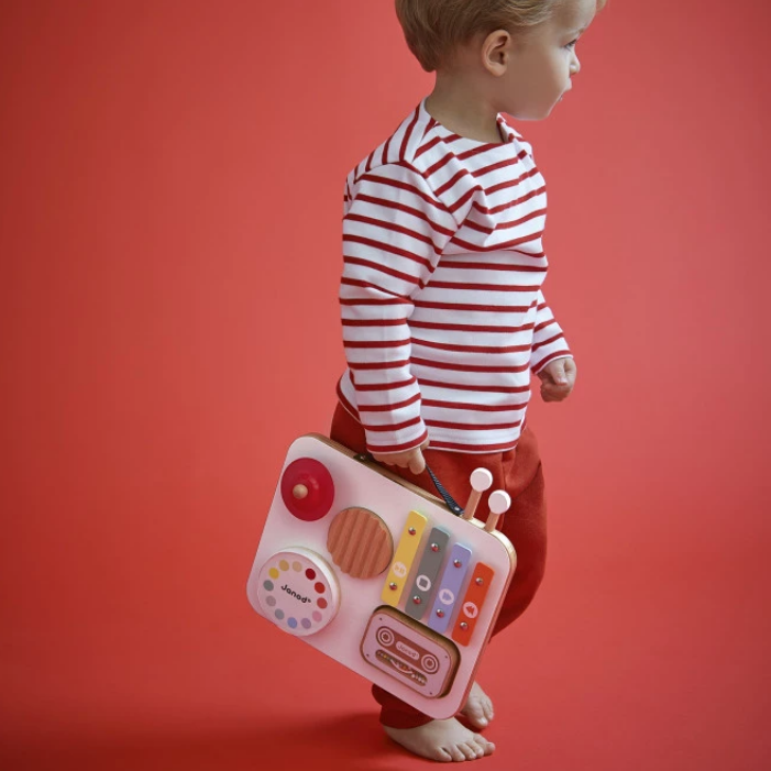 Child holding a toy radio against a red background