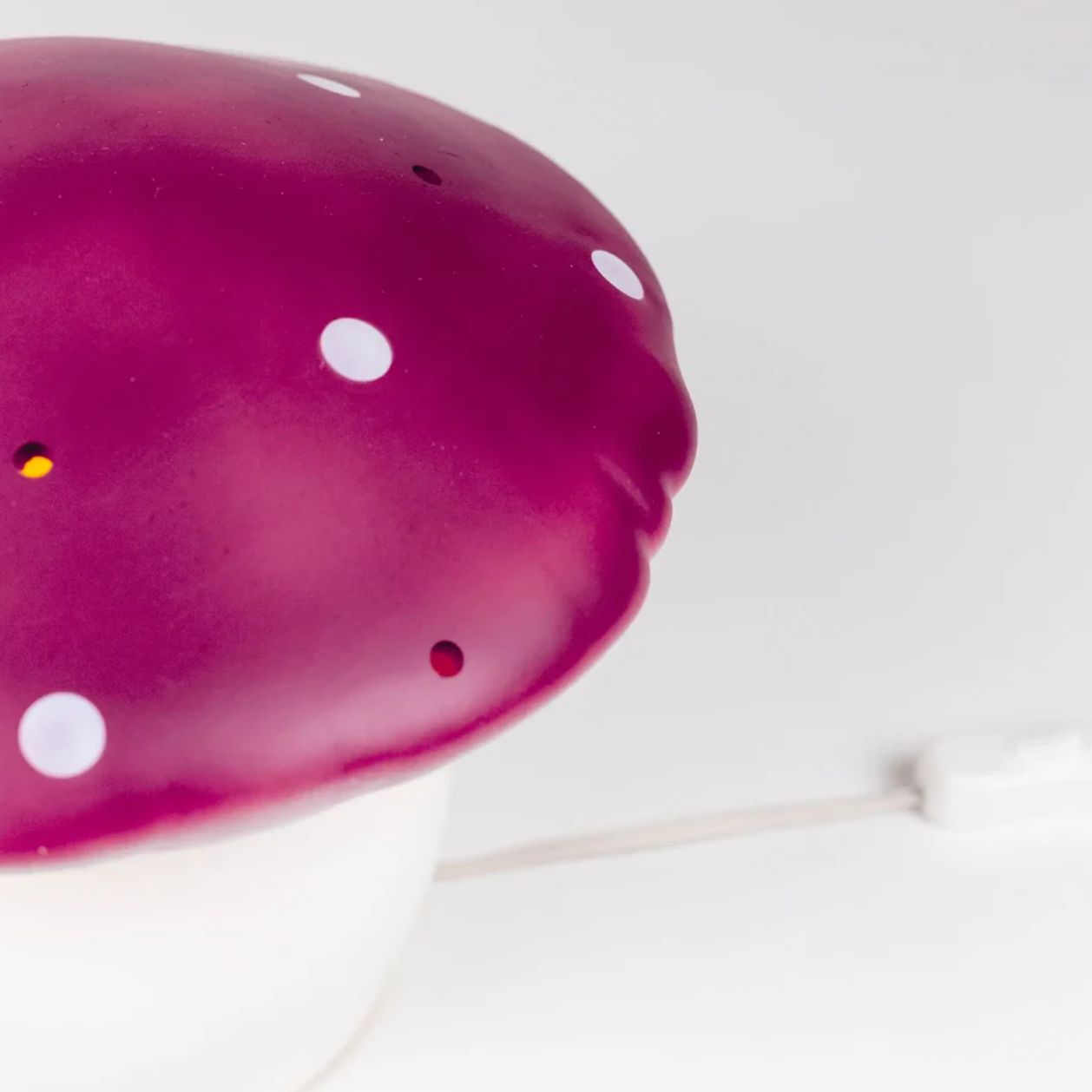 Close-up of a pink object with white polka dots on a light background