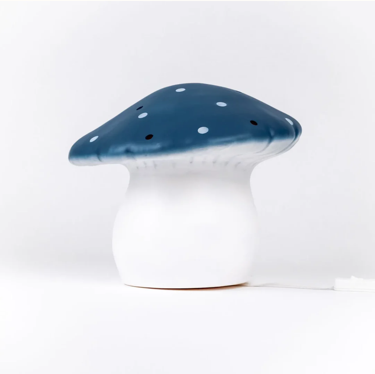 Mushroom-shaped lamp with blue cap and white stem on a white background