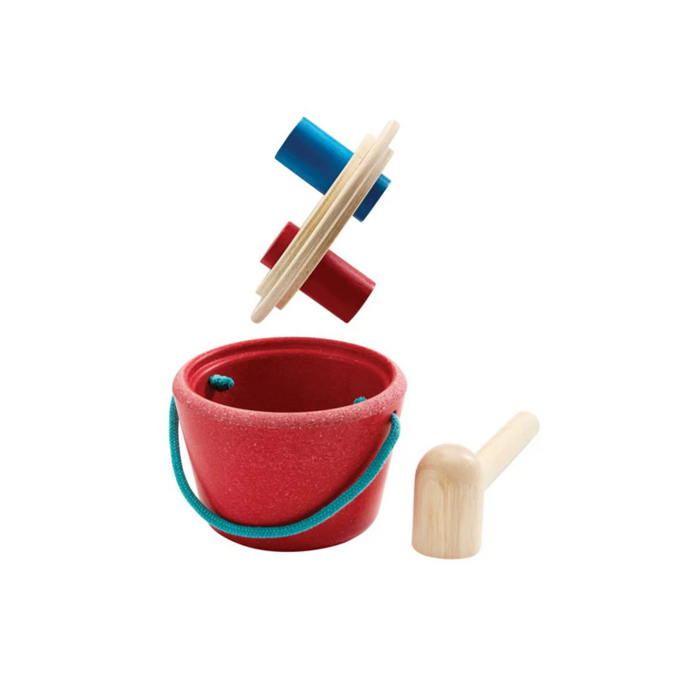 Red bucket with wooden spout and colorful rings on a white background
