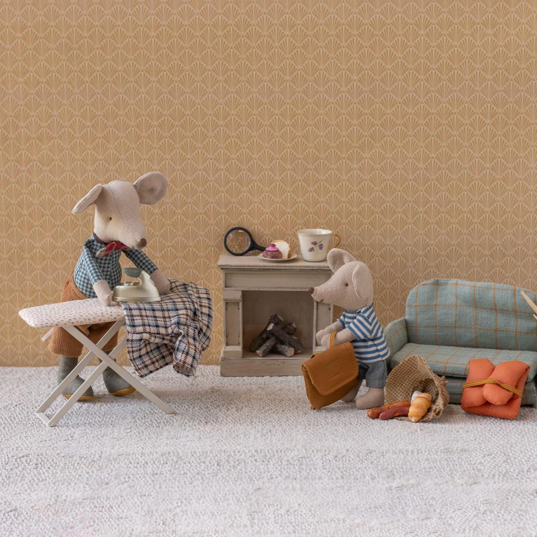 Miniature diorama with toy mice in a living room setting.