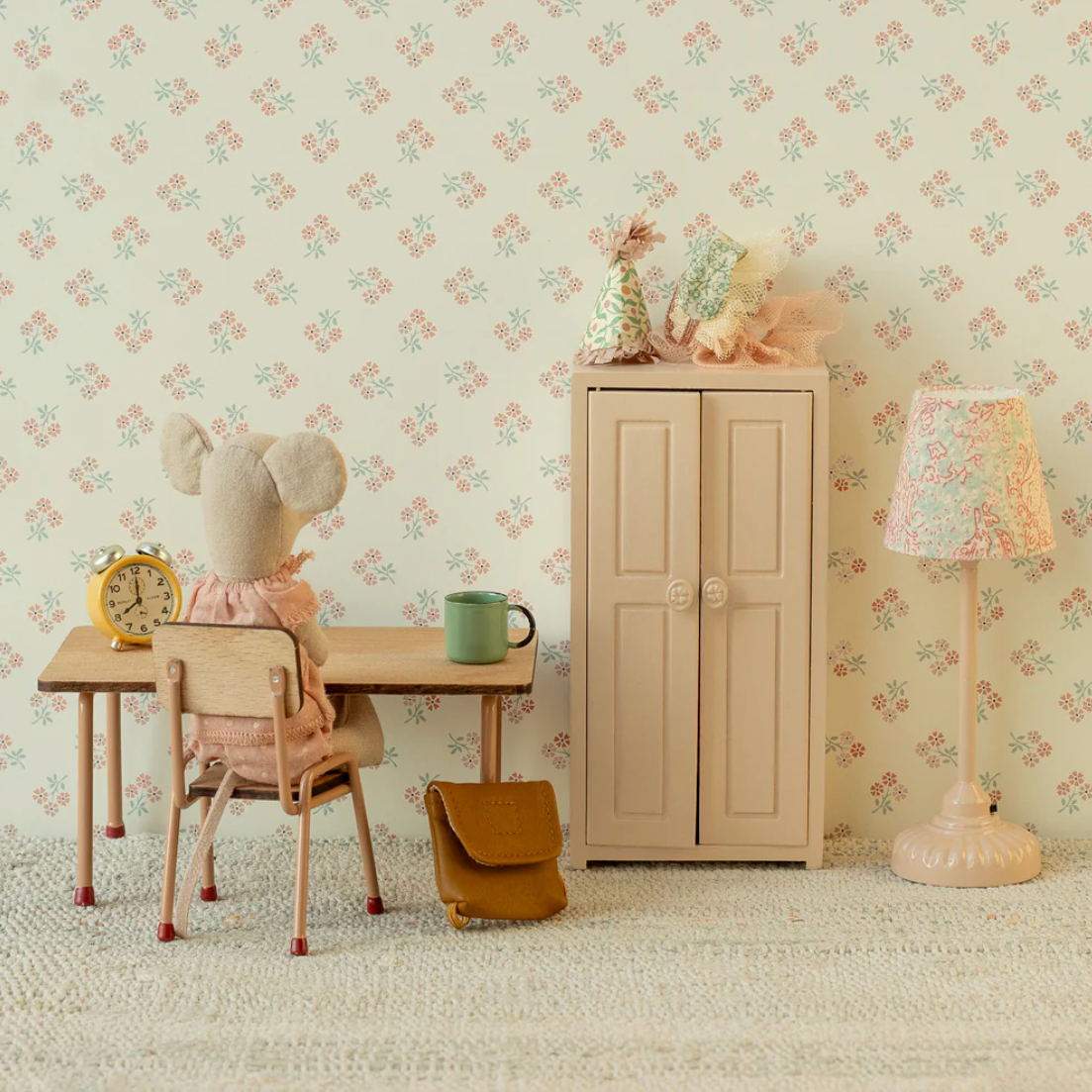 Children's room with floral wallpaper, desk, chair, and cabinet.