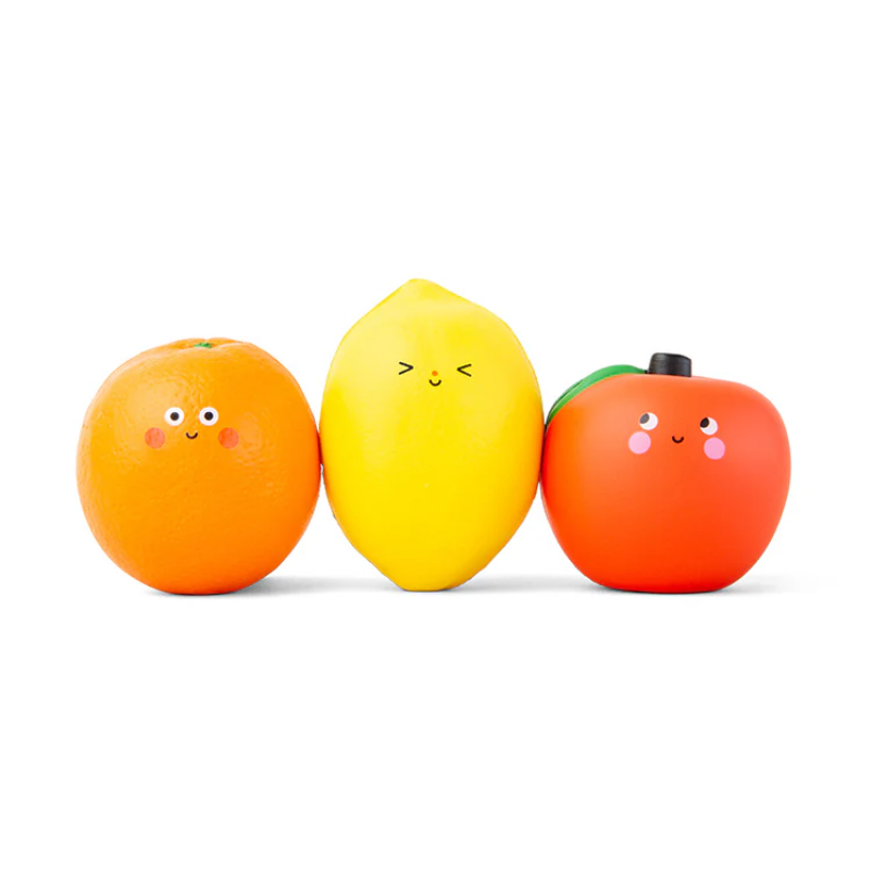 Three toy fruits (orange, lemon, and apple) with smiling faces on a white background