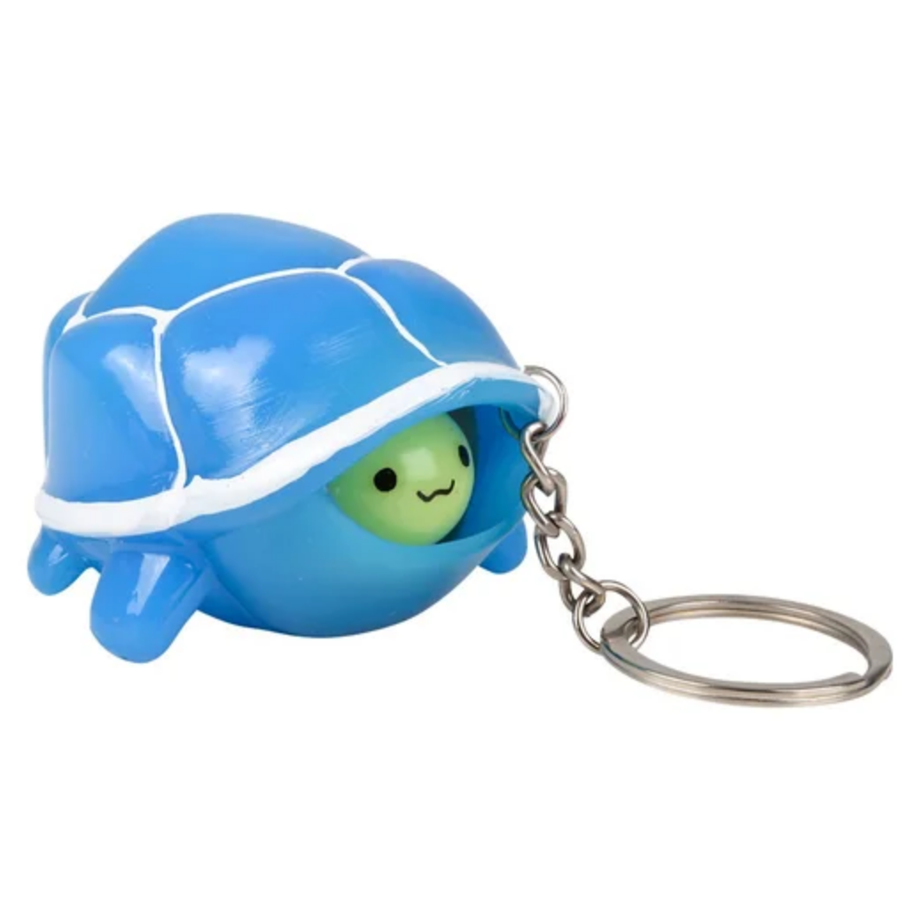 Blue turtle-shaped keychain with a smiling face on a white background