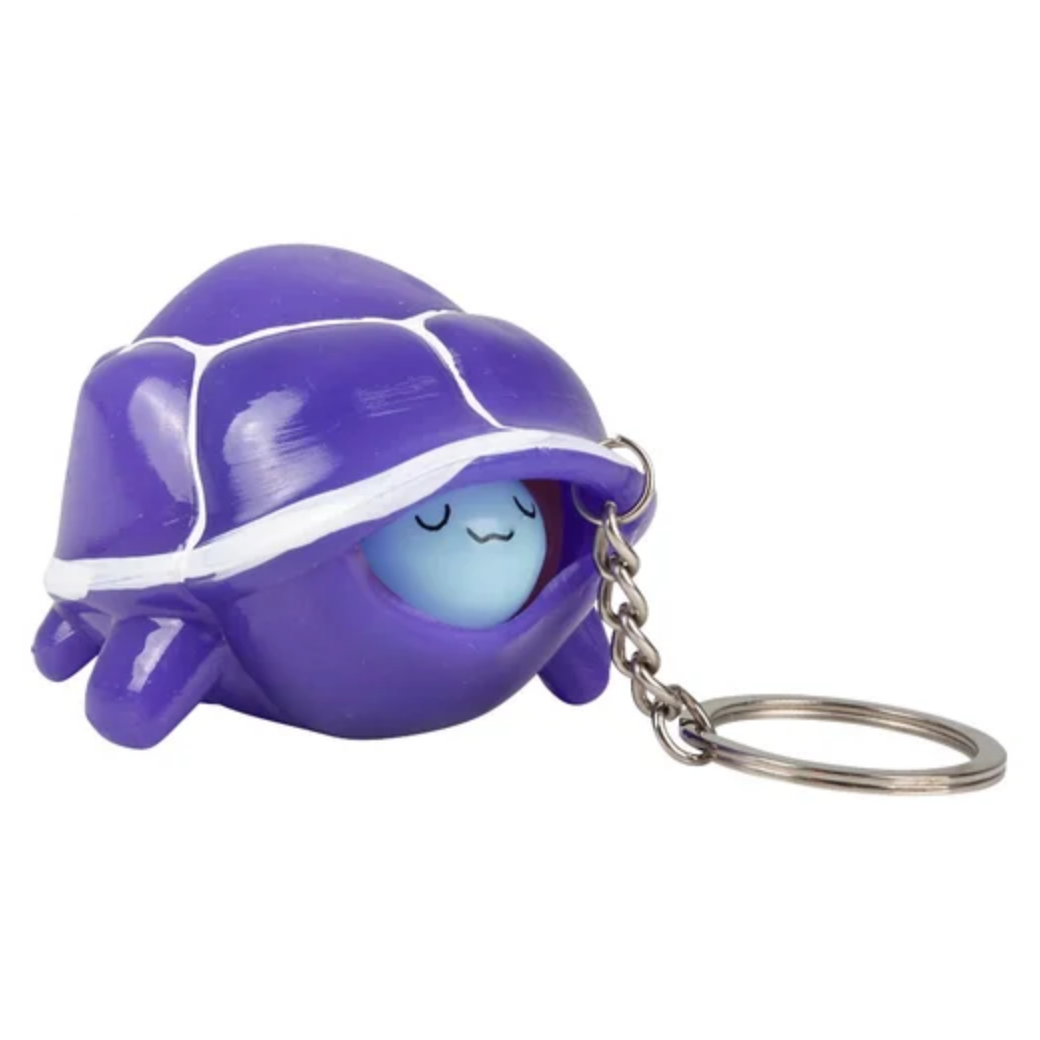 Purple shell-shaped keychain with a blue face on a white background