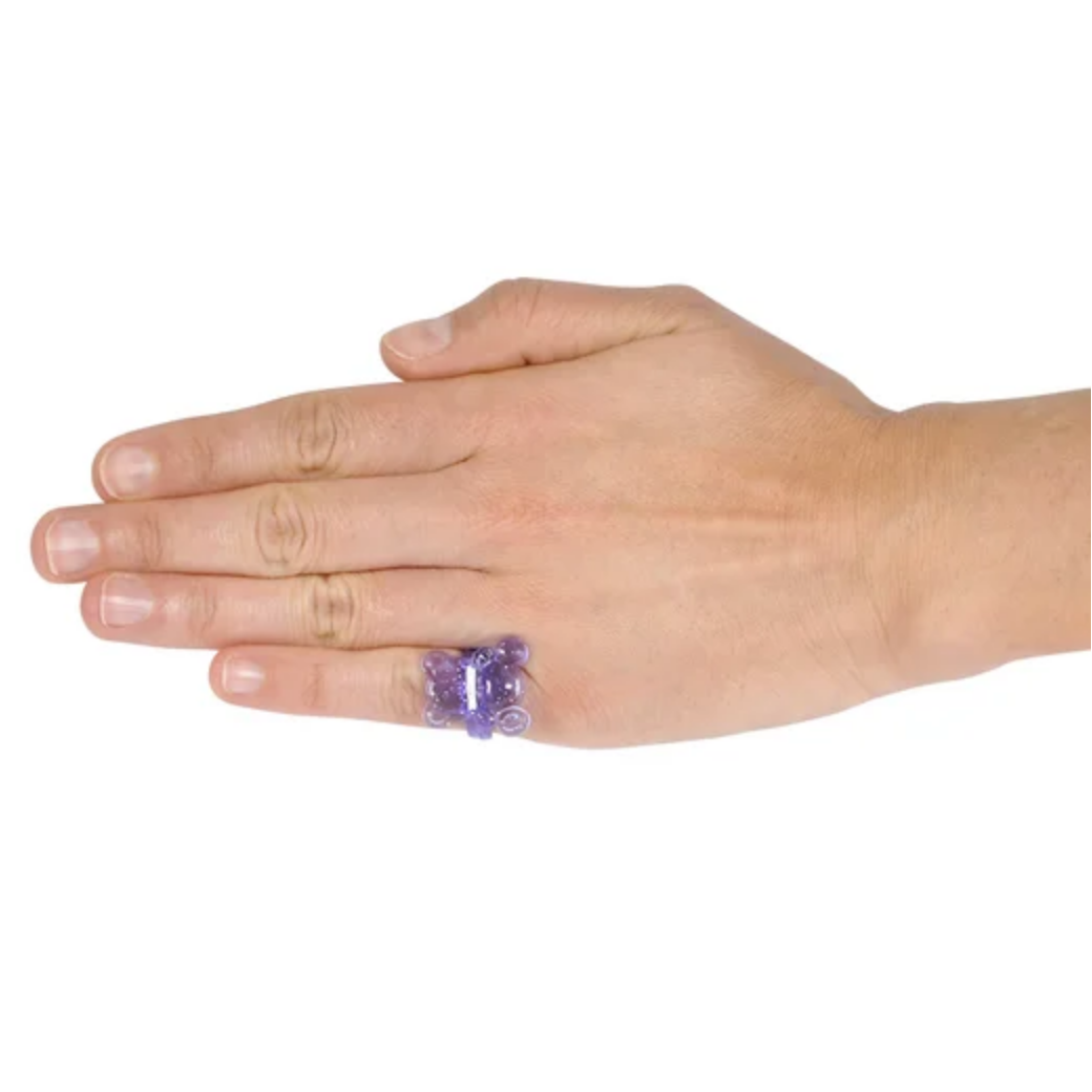 Hand wearing a purple ring on a white background 