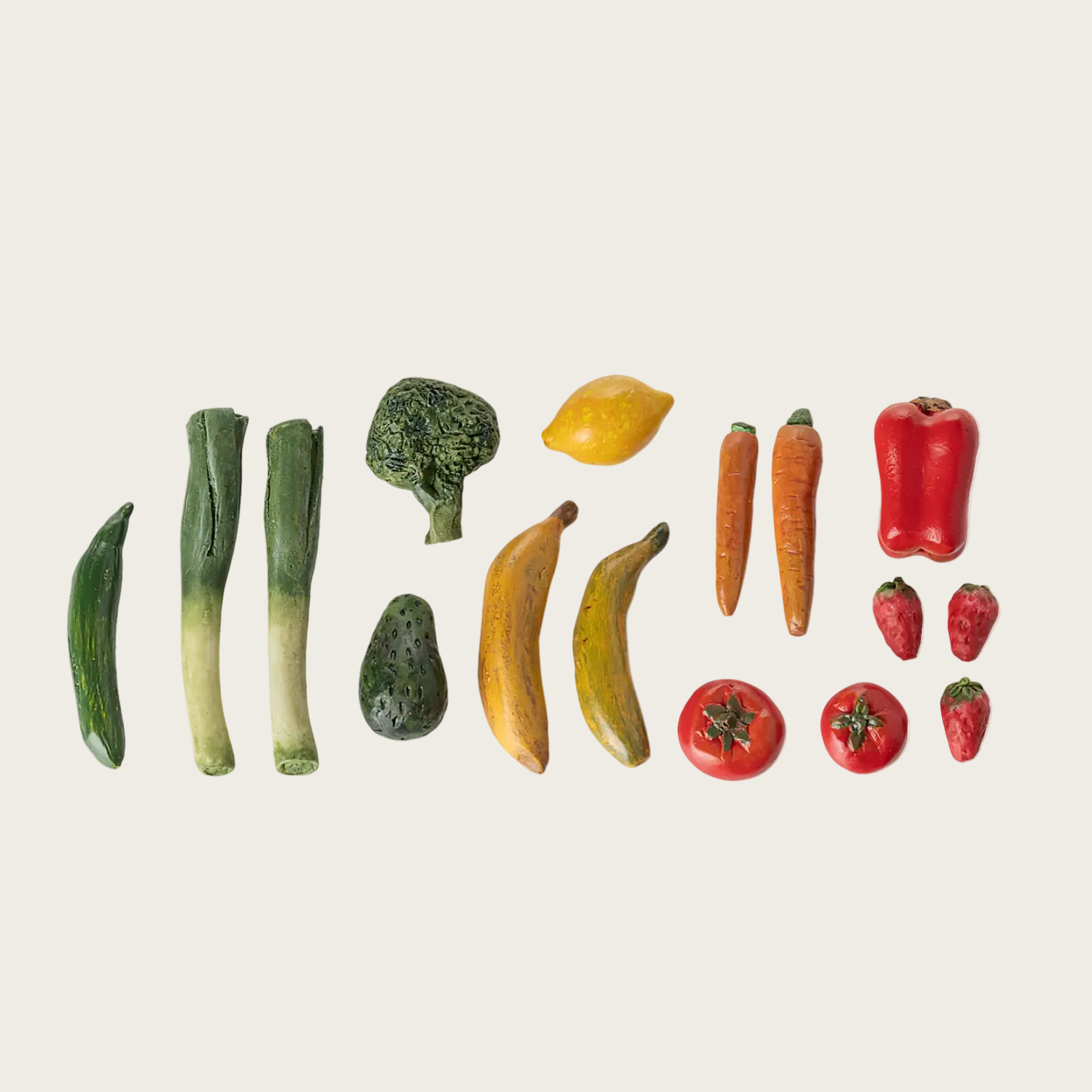 Fruits and vegetables arranged in a line on a beige background