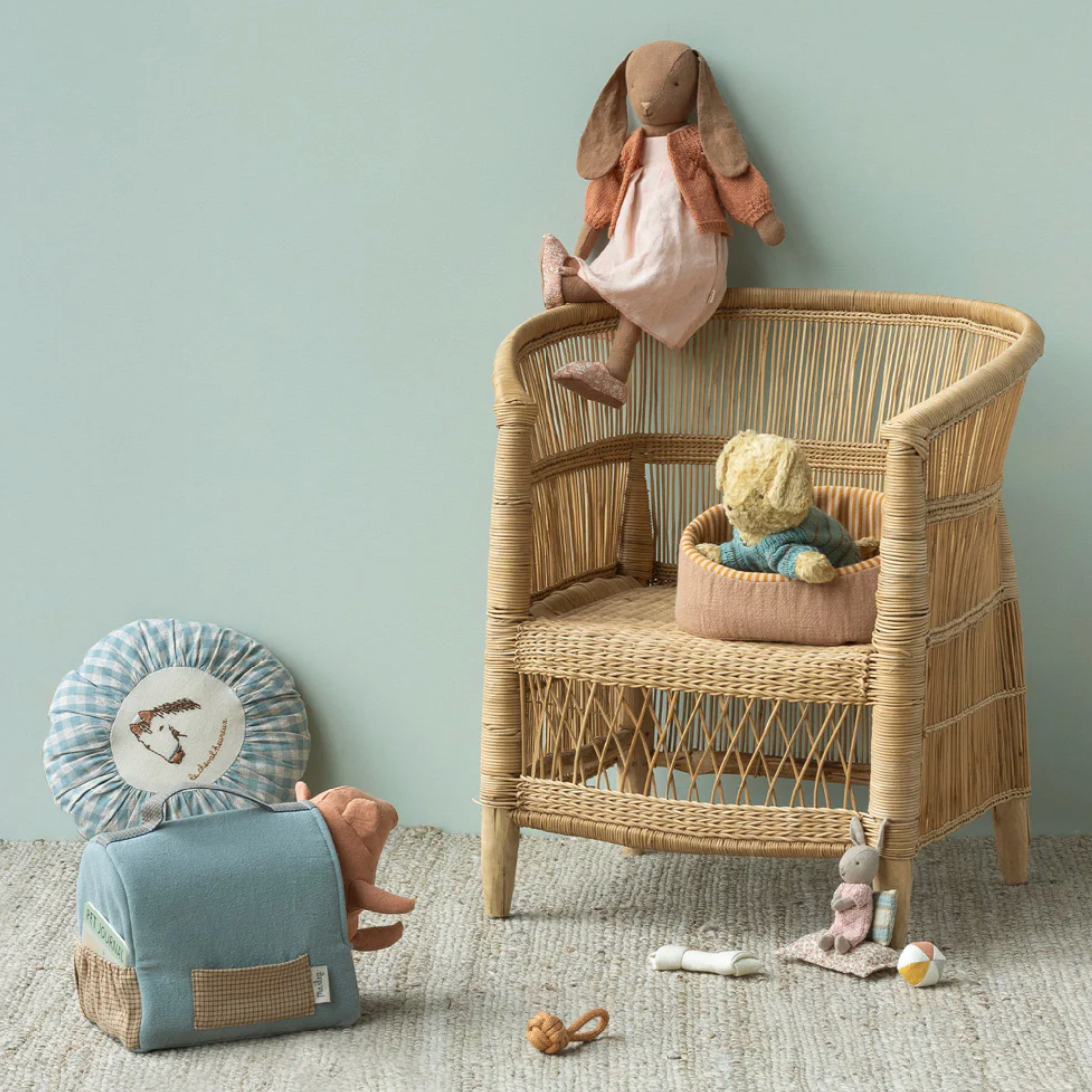 Wicker crib with toys against a light blue wall