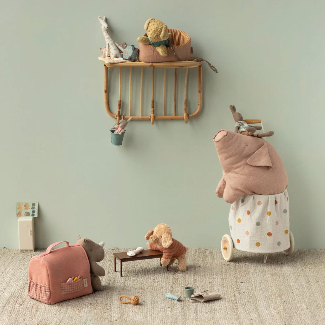 Children's room with toys and a shelf against a light green wall.