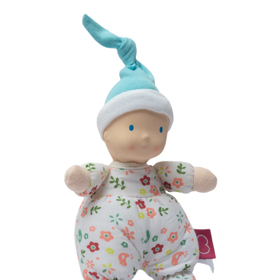 Baby doll with floral outfit and blue hat on a white background