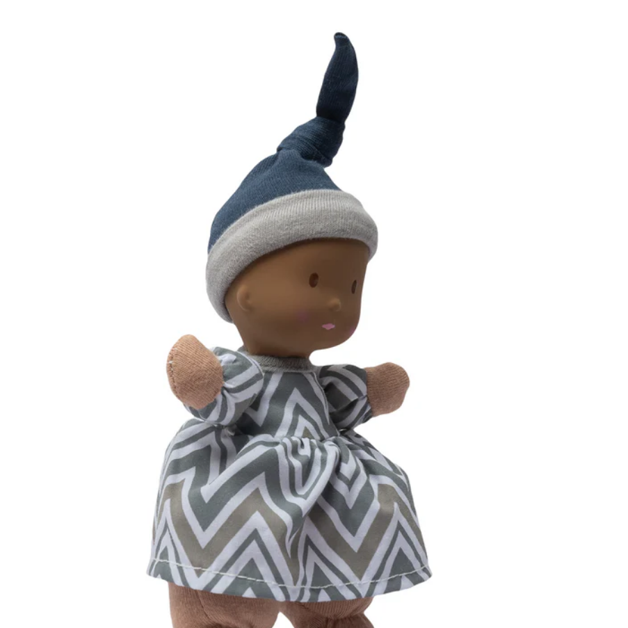 Doll with a blue and gray striped hat and a gray and white zigzag dress on a white background.