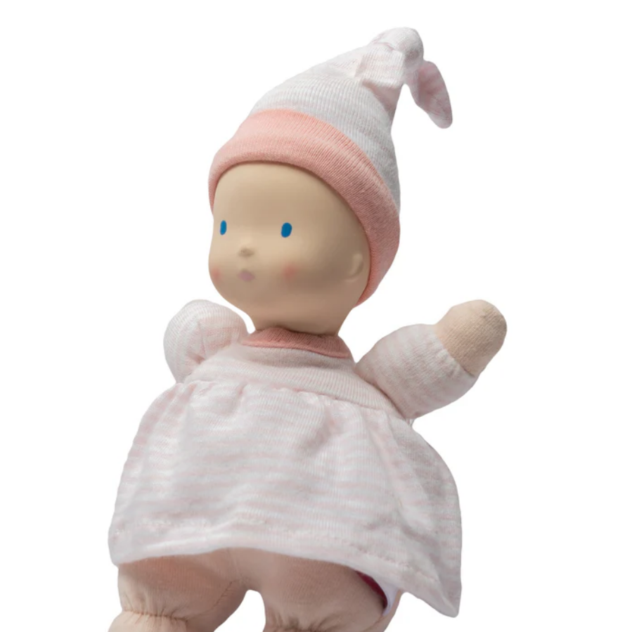 Baby doll with pink outfit and hat on a white background