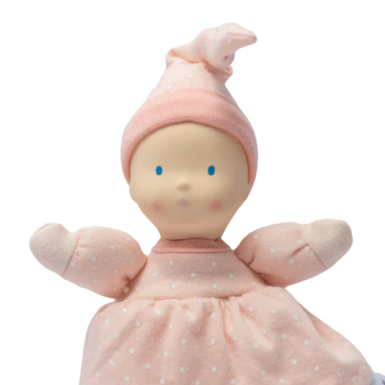 Stuffed doll with pink outfit and hat on a white background