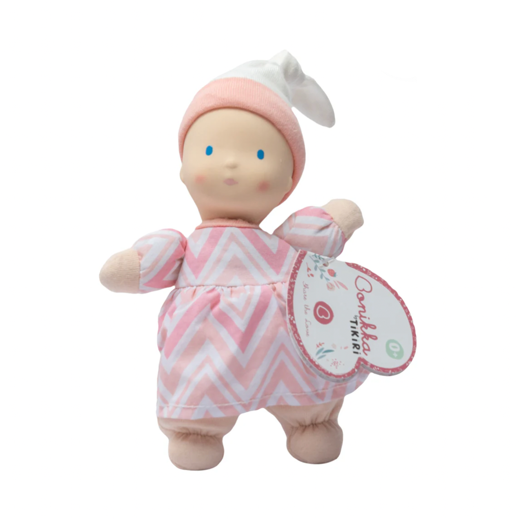 Baby doll with pink outfit and white hat on a white background